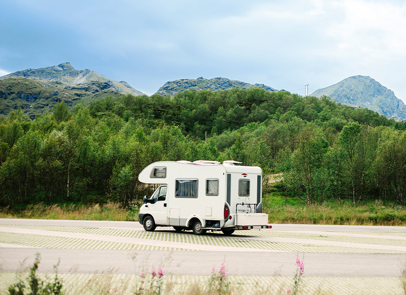 Fahrender Caravan in einem Berg-Waldpanorama 